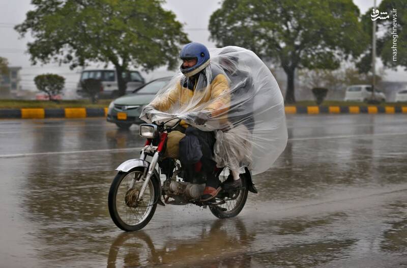 پوشش عجیب موتورسوار در روز بارانی پاکستان+عکس