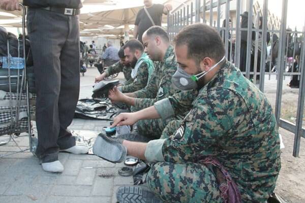 ماموران یگان ویژه‌ در حال واکس زدن کفش زوار +عکس