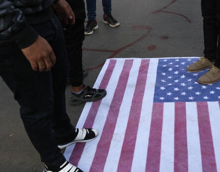معترضین عراقی پرچم آمریکا را لگدمال کردند +عکس