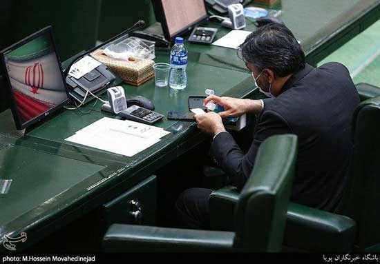 یک نماینده در حال تمیز کردن موبایل در مجلس+عکس