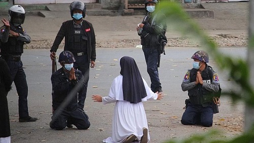 زنی که مقابل پلیس ضدشورش زانو زد+عکس